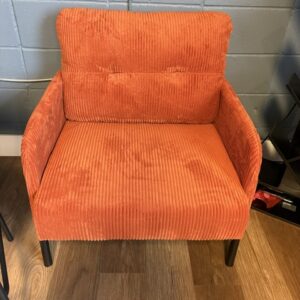 Nyhla orange velvet rubbed armchair on black metal base with side pockets . 28x28, 16”seat, 32”back